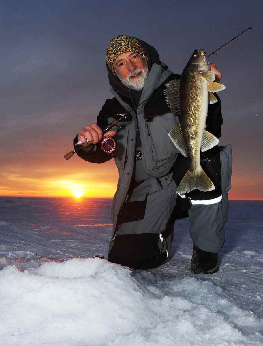 Участник IceClub позирует с трофейной рыбой на льду.